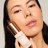 Model using INIKA Organic Phytofuse Renew Serum in her skincare routine