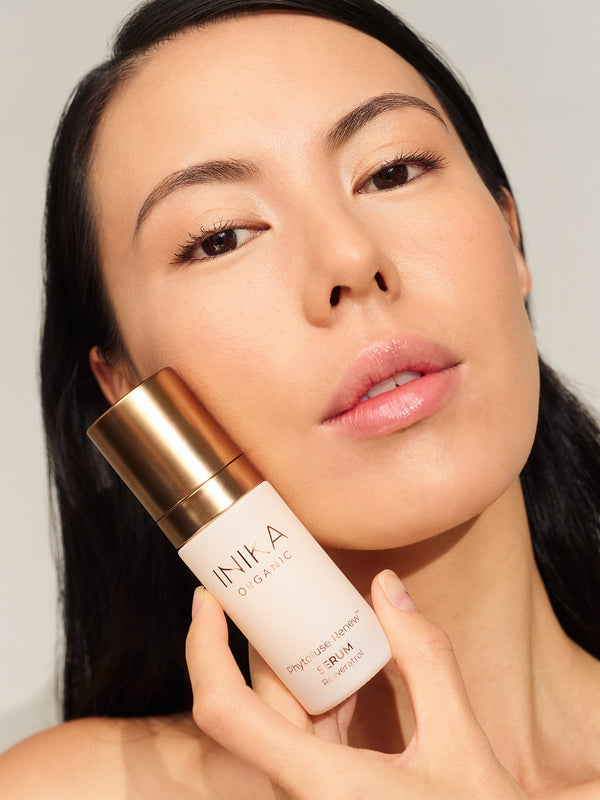 Model using INIKA Organic Phytofuse Renew Serum in her skincare routine