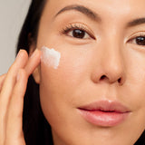 Model applying INIKA Organic Phytofuse Renew Day Cream to her face