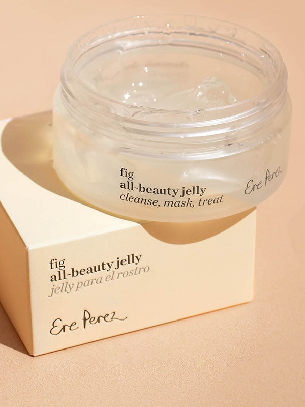 Ere Perez Fig All-Beauty Jelly open jar resting on its box against a peach background