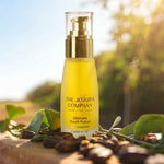 The Jojoba Company Ultimate Youth Potion bottle on a wooden surface with greenery behind