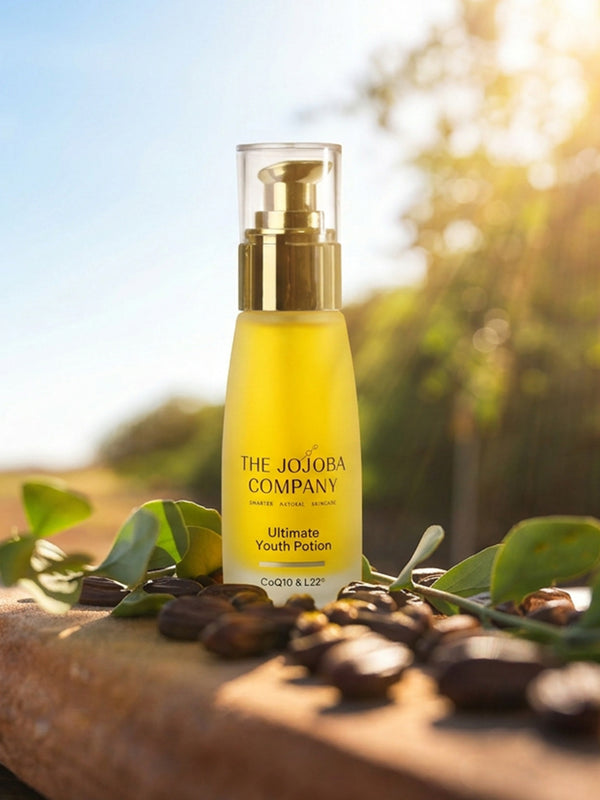 The Jojoba Company Ultimate Youth Potion bottle on a wooden surface with greenery behind