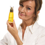 Woman holding a bottle of The Jojoba Company Ultimate Youth Potion
