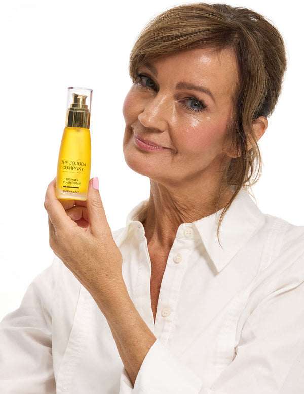 Woman holding a bottle of The Jojoba Company Ultimate Youth Potion