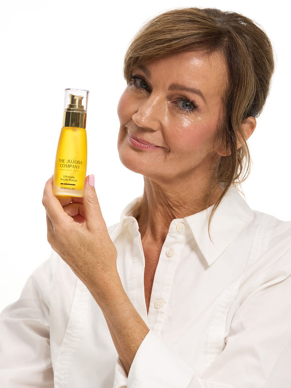 Woman holding a bottle of The Jojoba Company Ultimate Youth Potion