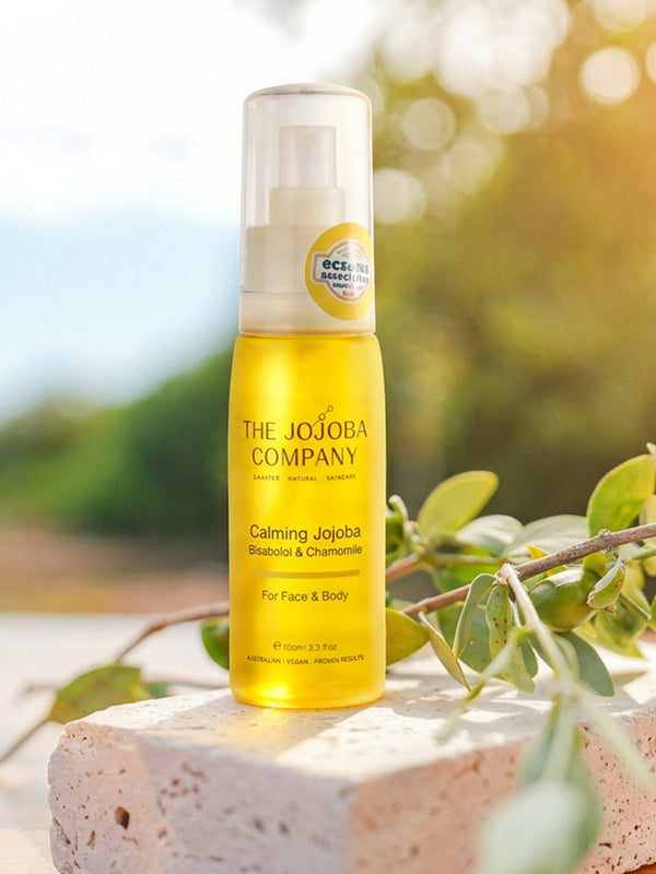 The Jojoba Company Calming Jojoba bottle standing on a stone surface