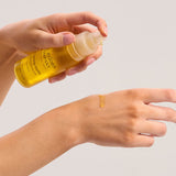 Dispensing The Jojoba Company Calming Jojoba onto the back of the hand