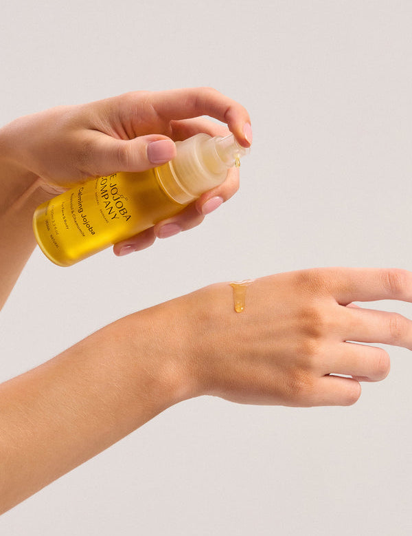 Dispensing The Jojoba Company Calming Jojoba onto the back of the hand