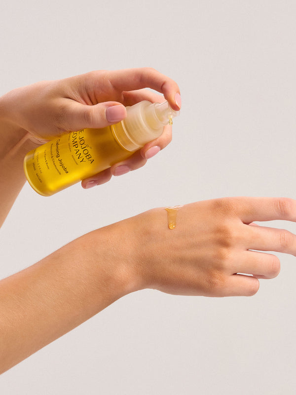Dispensing The Jojoba Company Calming Jojoba onto the back of the hand