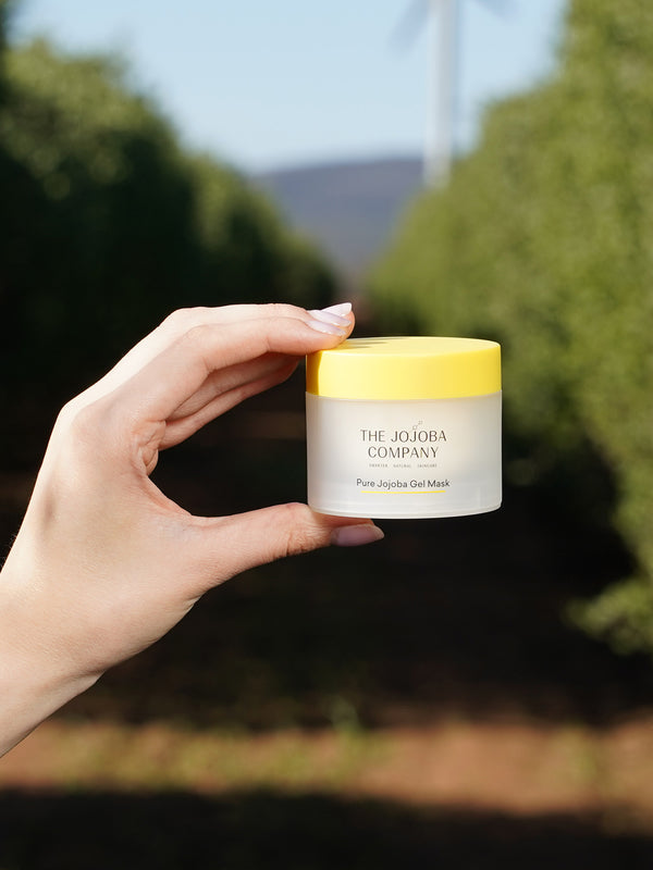 Hand holding a jar of The Jojoba Company Pure Jojoba Gel Mask
