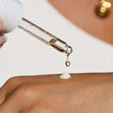 Drop of Ere Perez Guava Gradual Tan falling from the dropper onto the back of a hand