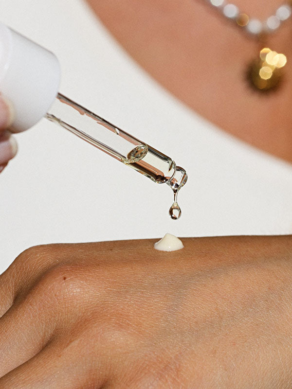 Drop of Ere Perez Guava Gradual Tan falling from the dropper onto the back of a hand