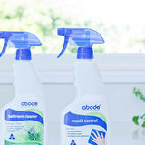 Abode Bathroom Cleaner and Mould Control spray bottles on a windowsill in natural light