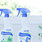 Abode Oxy Action Mould Control Spray beside the Bathroom Cleaner on a windowsill in natural light