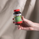 Hand holding the Herbs of Gold Children's Magnesium Care bottle