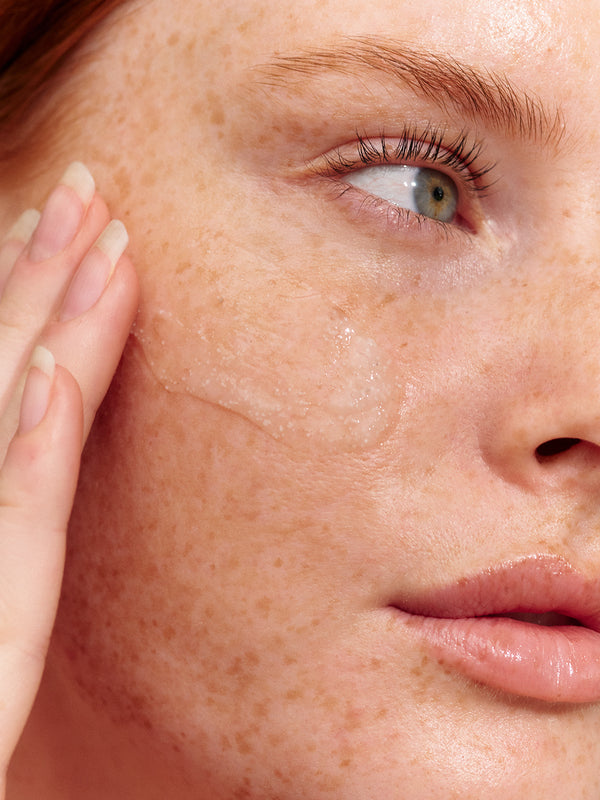 Model using INIKA Organic Phytofuse Renew Exfoliator on her skin