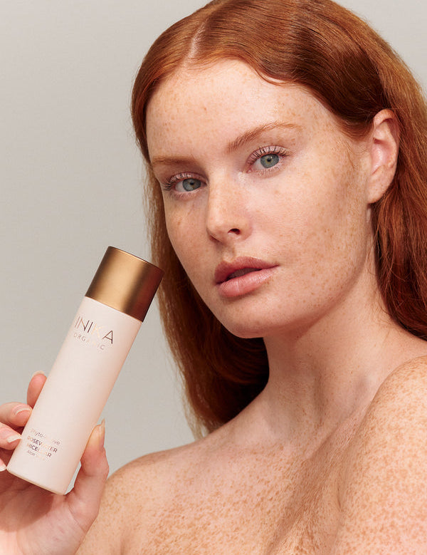 Model cleansing her face with INIKA Organic Phyto-Active Rosewater Micellar