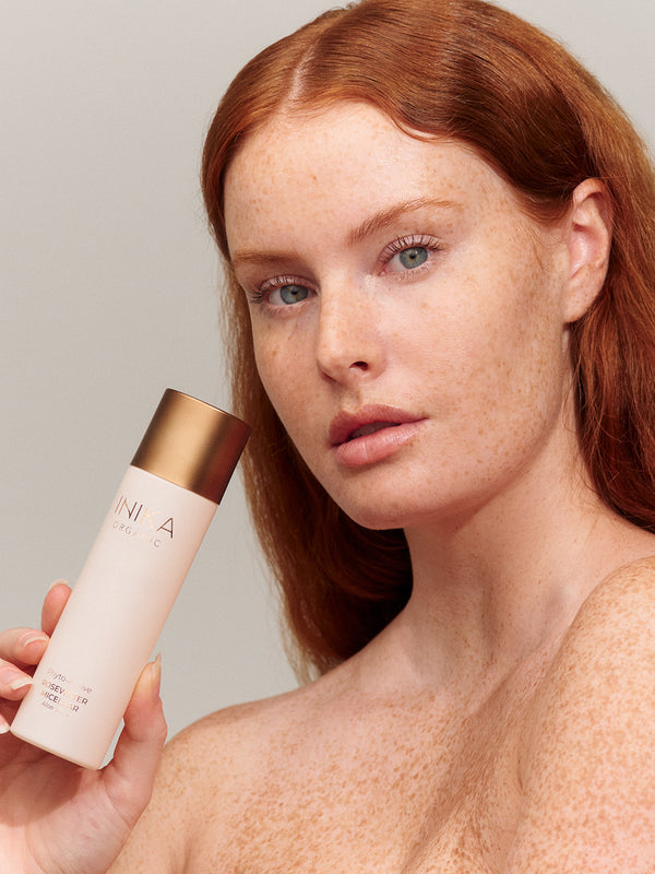 Model cleansing her face with INIKA Organic Phyto-Active Rosewater Micellar