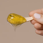 Close-up of Mukti Deep Cleanse Enzyme Mask gel on a wooden spatula