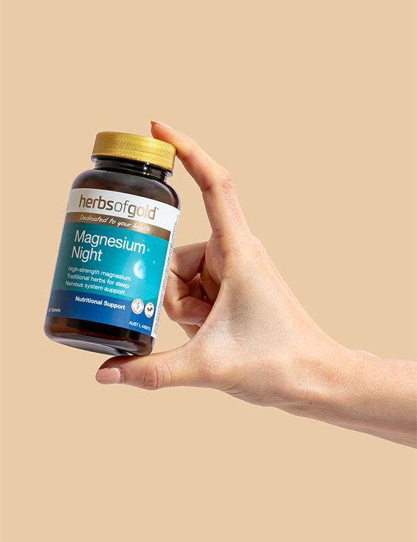 Hand holding the Herbs of Gold Magnesium Night bottle