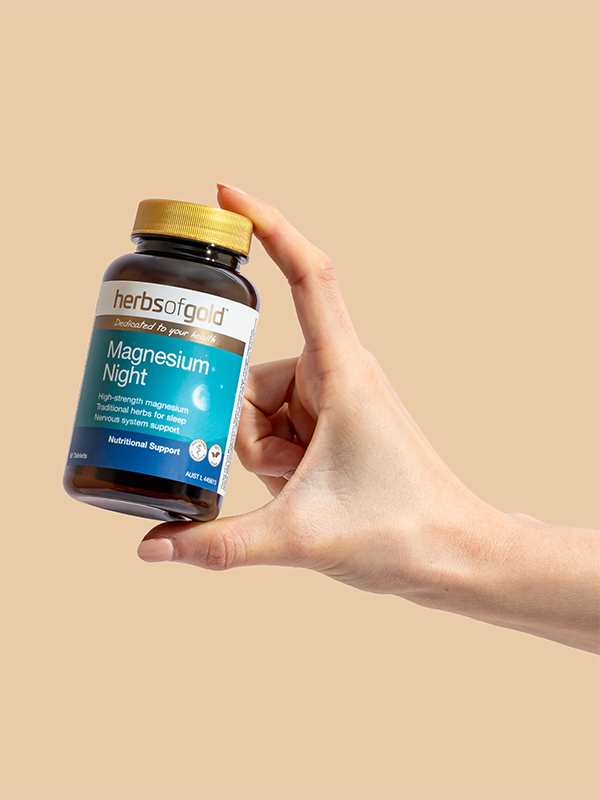 Hand holding the Herbs of Gold Magnesium Night bottle