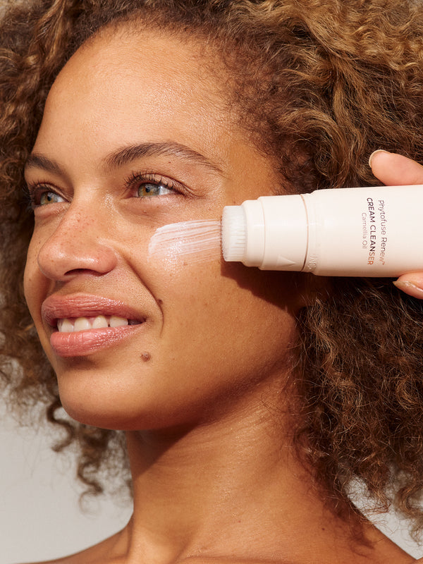 Model using INIKA Organic Phytofuse Renew Cream Cleanser in her skincare routine