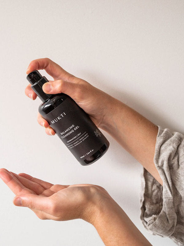 Hands pumping Mukti Balancing Cleansing Gel into an open palm