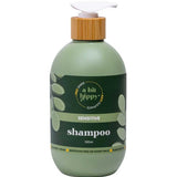 Green shampoo bottle with bamboo cap on a white background