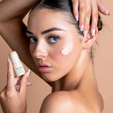 Model applying Avocado Zinc SPF50 Natural Concealer in Light to her cheek.