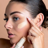 Model blending Avocado Zinc SPF50 Natural Concealer in Light-Medium beneath her eye.