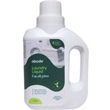 A white 1L bottle of Abode Laundry Liquid Eucalyptus with a handle and green label, showing folded towels, a washing machine, and product information. Biodegradable.