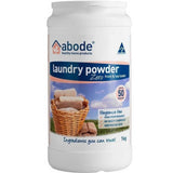 A white container of Abode Laundry Powder Zero - Fragrance Free, with a wicker basket of towels. The label shows it's suitable for sensitive skin, front and top loaders, fragrance-free, and comes in a 1 kg size.