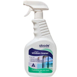 A white spray bottle labeled Abode Natural Window Cleaner 750ml, with green accents and a window graphic. The bottle promises streak-free cleaning and trustworthy ingredients for spotless, clear windows.