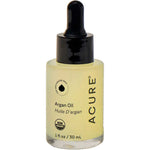 A bottle of Acure Argan Oil with a black dropper cap and a clear glass bottle showing the pale yellow oil inside, set against a plain white background.