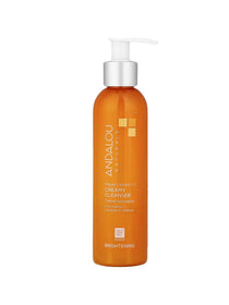 An orange bottle of Andalou Brightening Meyer Lemon + Vitamin C Creamy Cleanser 178ml with a white pump highlights its brightening formula and vitamin C benefits for glowing, defended skin.