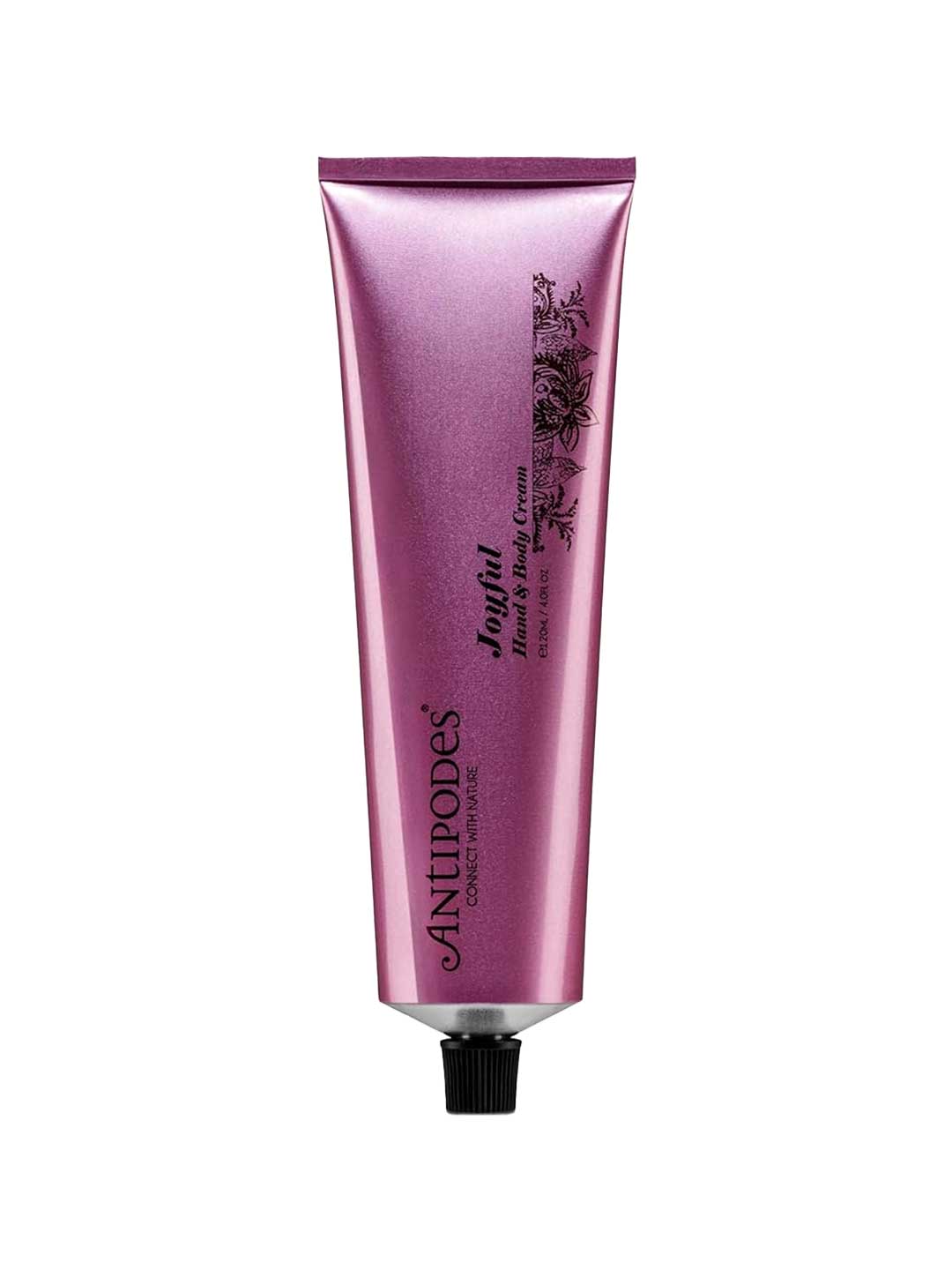 A metallic pink tube of Antipodes Joyful Hand & Body Cream 120ml, featuring black floral graphics and a black screw cap, stands upright against a white background—ideal for vegan skincare and dry skin.