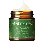 A brown jar of Antipodes Kiwi Seed Oil Eye Cream 30ml with green and gold accents contains creamy white natural eye cream. Made in New Zealand, it targets dark circles and comes in a 1.0 fl oz size.