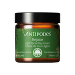 A 60ml brown jar of Antipodes Rejoice Light Facial Day Cream with a green label, featuring natural ingredients like manuka flower oil and organic avocado oil, plus certification details.