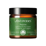 A 60ml brown jar of Antipodes Rejoice Light Facial Day Cream with a green label, featuring natural ingredients like manuka flower oil and organic avocado oil, plus certification details.