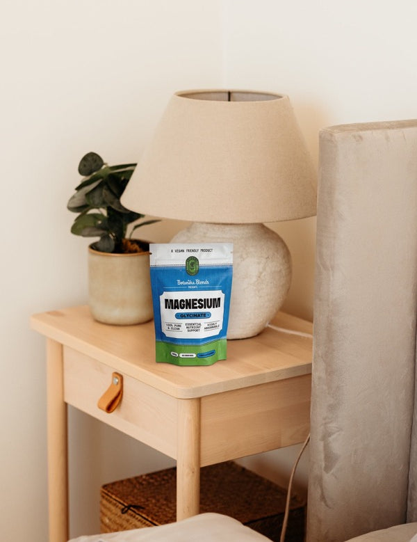 Botanika Blends Magnesium Glycinate beside a bedside table
