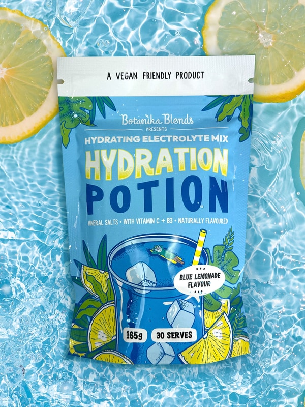 Botanika Blends Blue Lemonade Hydration Potion in water with lemons