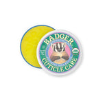 A round tin of Badger Cuticle Care 21g features a badger illustration and USDA Organic seal on the lid. The open tin reveals yellow balm inside, ideal for cuticle care.