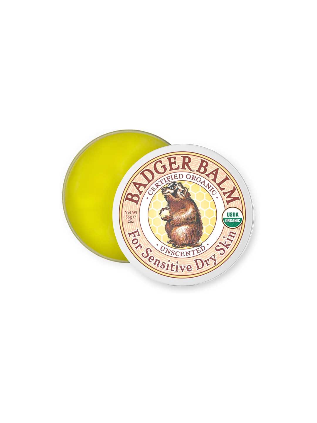 A partially open tin of Badger Unscented Healing Balm 56g reveals yellow balm inside. The lid displays a badger illustration and text stating certified organic and unscented—ideal for gentle, organic skin care.