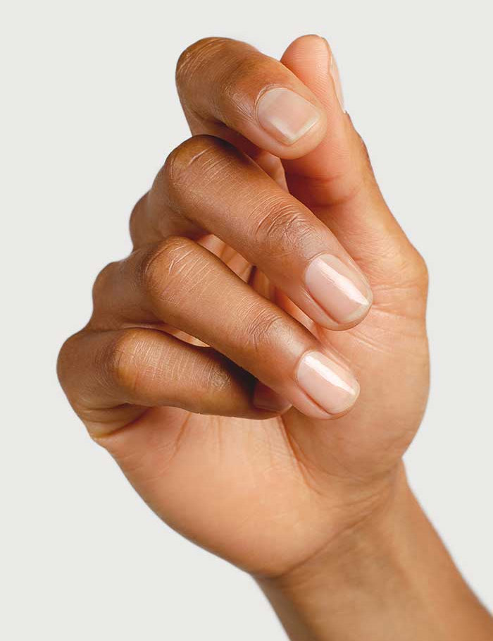 A close-up of a hand with nails painted in Sienna Byron Bay Nail Polish - Base Coat, a plant-derived formula that provides a clear, glossy, and sticky base for a flawless finish.
