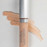 A 5ml tube of Benecos Concealer labeled Light with a silver cap stands before a swatch of its light beige shade on a gray background.