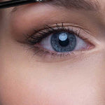 Close-up of a person's blue eye and well-groomed brows as Benecos Eyebrow Gel 3ml is applied with a makeup brush to shape and fill in the eyebrow.