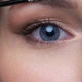 Close-up of a person's blue eye and well-groomed brows as Benecos Eyebrow Gel 3ml is applied with a makeup brush to shape and fill in the eyebrow.