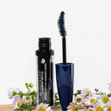 An open tube of Benecos Mascara Adorable Lashes Deep Ocean 5.5ml with a blue wand rests among white and yellow daisies on a light background, ideal for naturally lengthening lashes.