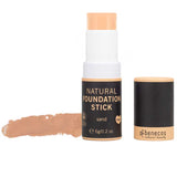 The Benecos Natural Foundation Stick 6g in Sand is shown uncapped, revealing the vegan, buildable organic stick foundation and a swatch beside its sleek black packaging with gold and white details.