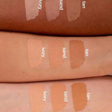 Three forearms of different skin tones display swatches of Benecos Natural Foundation Stick 6g in ivory, sand, and tan, demonstrating the buildable coverage these vegan shades offer across various complexions.